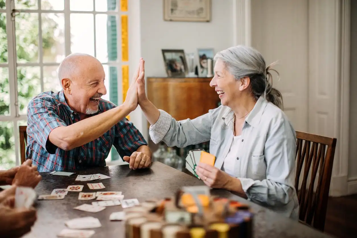 Tips for Financial Security An old woman and man doing high fives while playing cards
