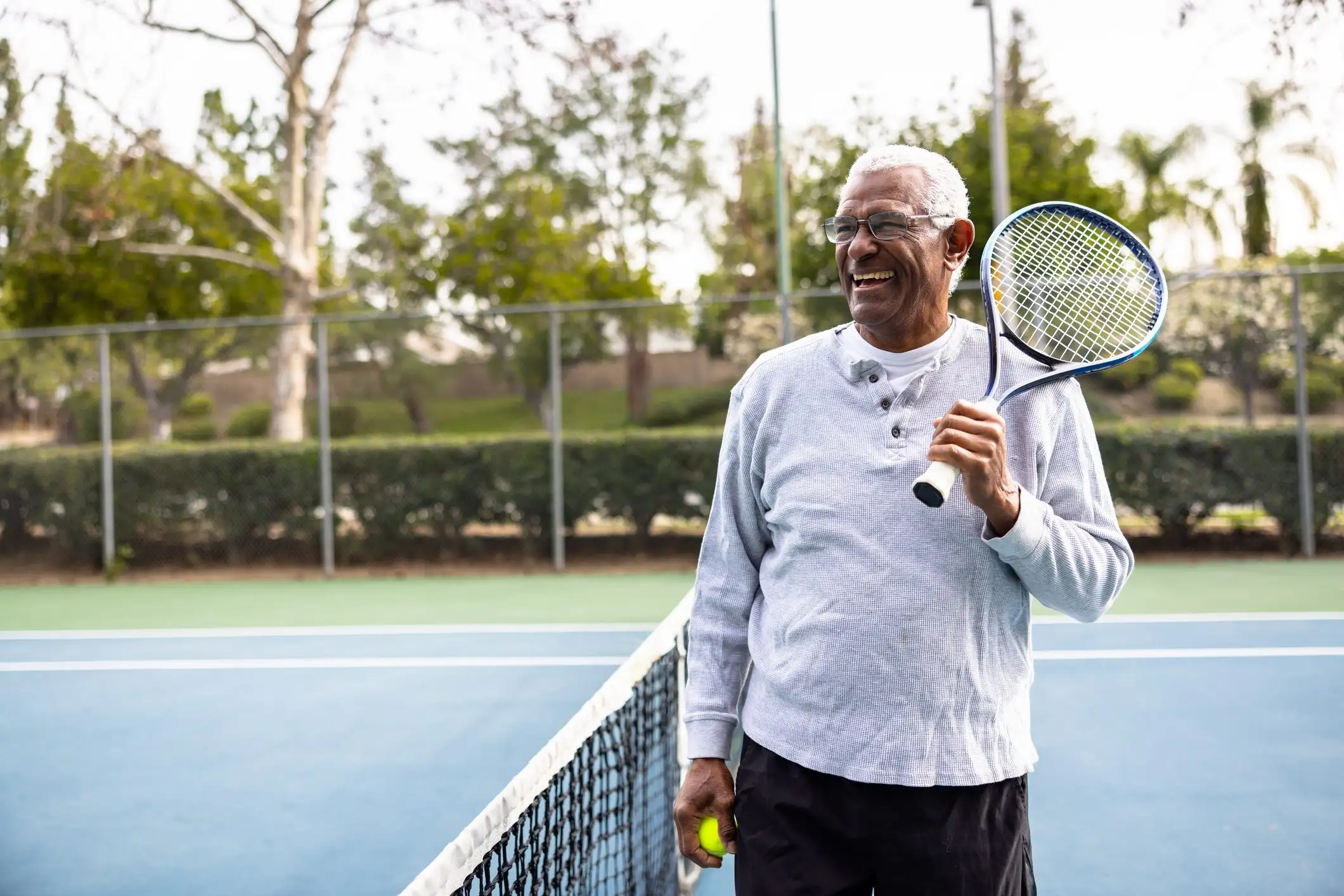 Portrait of a senior black man on the tennis court A senior black man smiling