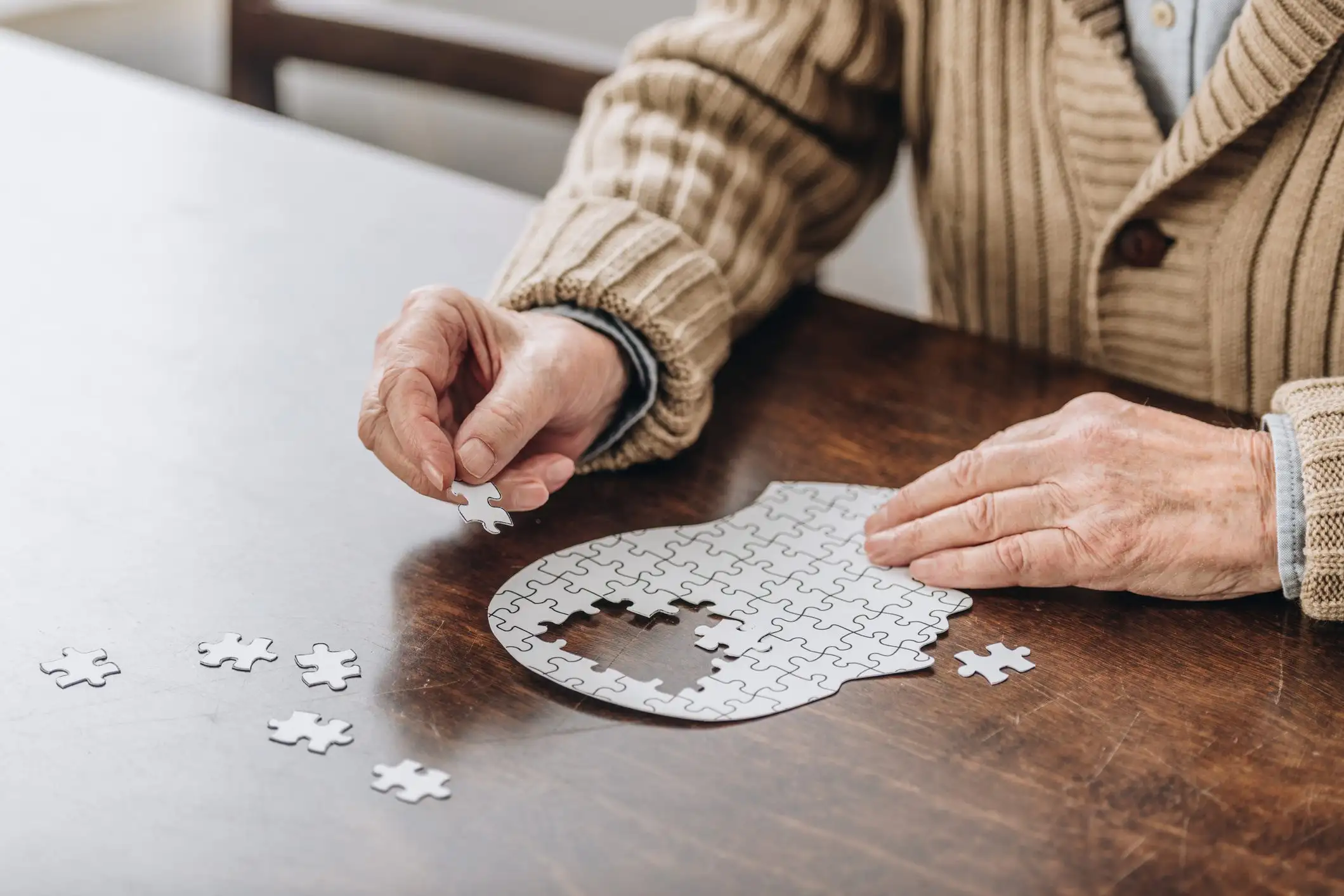 cropped view of senior man playing with puzzles cropped view of senior man playing with puzzles
